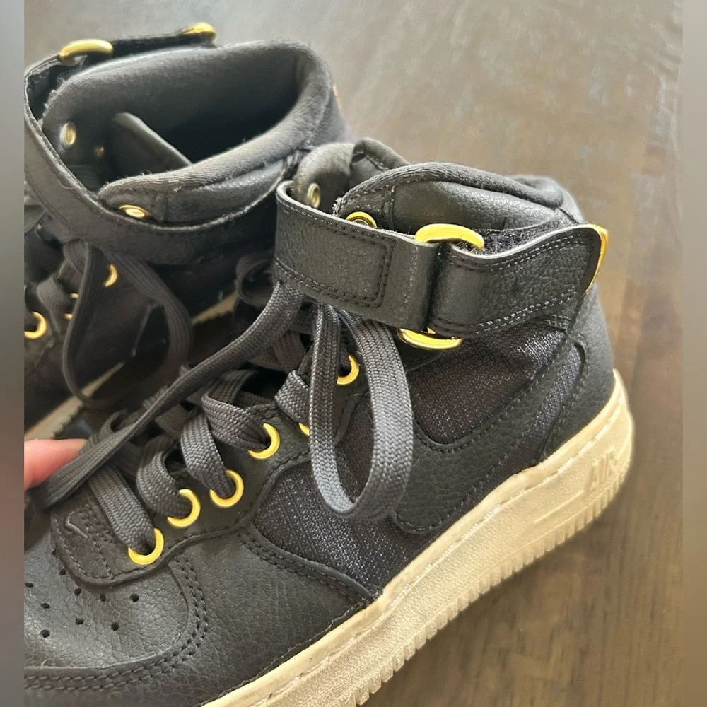 Nike Air Force ones black high top sneakers gold trim